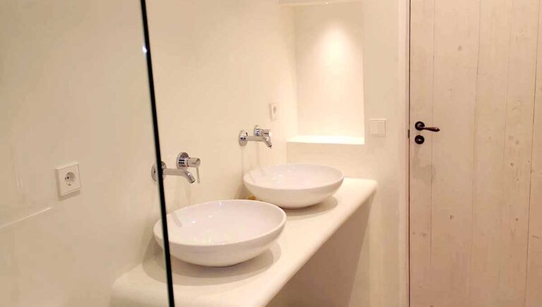 Badezimmerwände und weiße Mikrozement-Badezimmerarbeitsplatte in Santa Maria. Mallorca